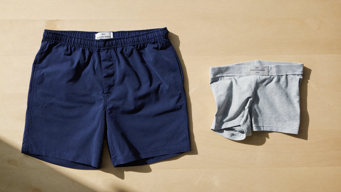 Swim trunks laid out next to folded cotton boxer shorts, showing the two do not belong together