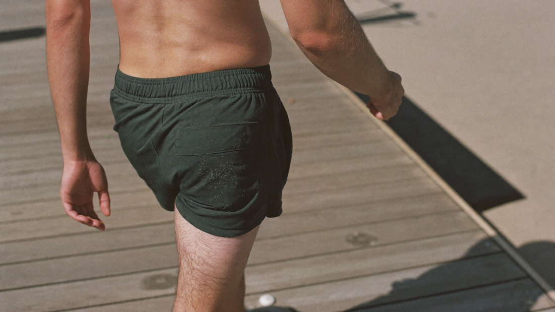 Man walking on a beach boardwalk in athletic shorts on a sunny morning